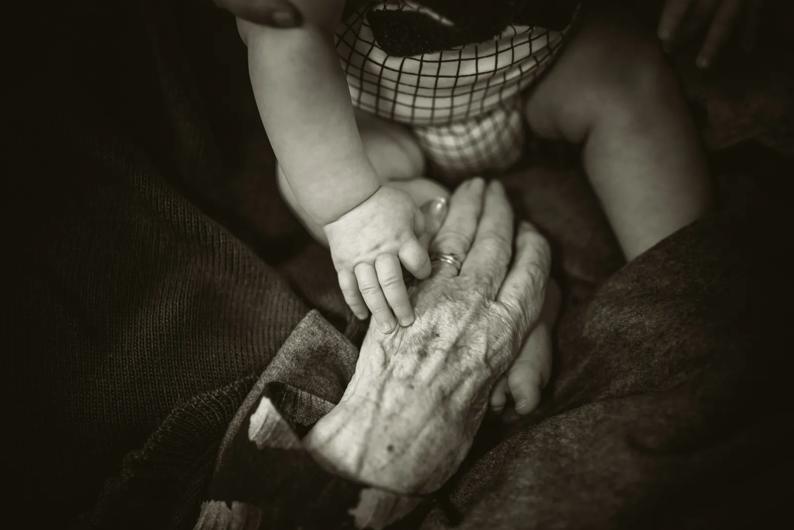 Main d'une personne &acirc;g&eacute;e tenant celle d'un enfant